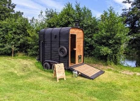 Converted horse box in feild with river access beside it